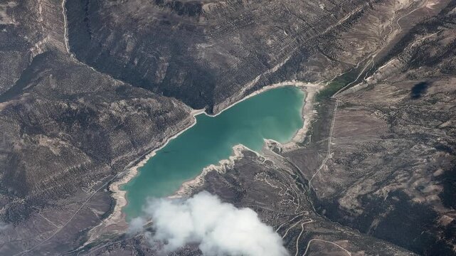flying along Joes Valley Reservoir with Joes Valley Dam, surrounded by Manti&ndash;La Sal National Forest,  located in Emery County, Utah, USA  - 4k aerial video footage 