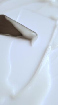 Creamy cosmetic texture spreading with spatula for skincare and beauty product demonstration