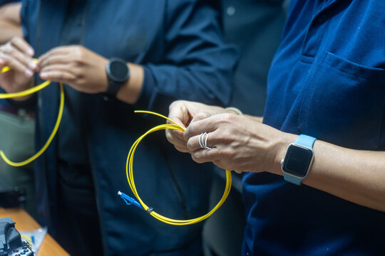 People Connecting Ethernet Cables in Data Center
