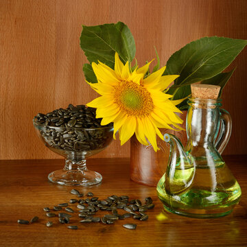 Golden Sunflower Oil Jar and Black Seeds on Wooden Table
