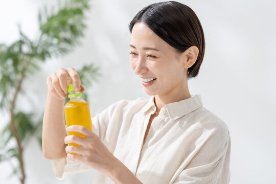 ペットボトルのお茶を飲む女性