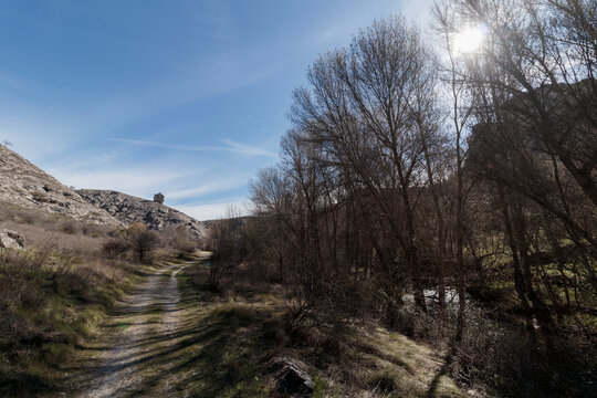 Rural path winding through rocky landscape and barren trees
