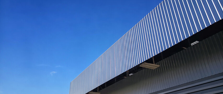 Metal sheet roof curve on blue sky. Modern construction, Metal ribbed arch span roof covering, Large building roof. not ai
