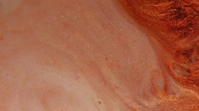 Shimmer flow. Art paint. Defocused orange bronze ink in water brick texture particles spilling on abstract marble milky background.