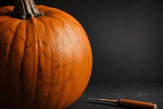 Large Orange Pumpkin with Carved Jack O Lantern Pattern and Carving Tool