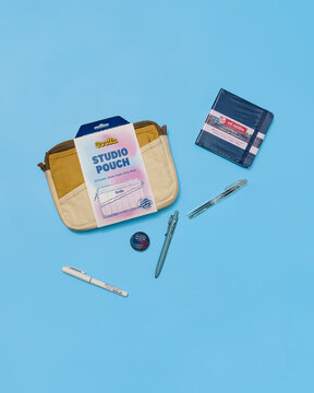 Stationery products flat lay. Sketchbook, pens, bag, tape, copy space
