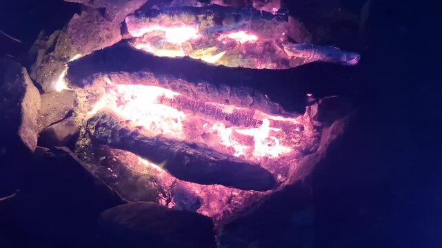 Glowing purple and orange light inside a dark rocky formation. Natural texture, geology, energy, mysterious atmosphere.