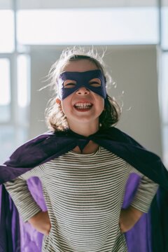 Young child in a purple superhero cape and mask smiling with confidence for childrens education and empowerment lifestyle content