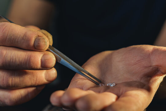 Caucasian elder male jeweler inspecting diamond with loupe at workshop, banner cutting on manufacturing