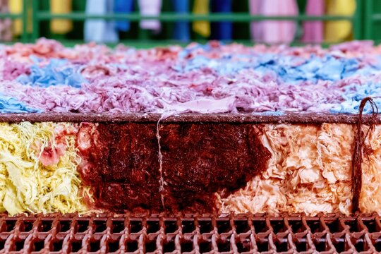 Tactile textile waste and colorful fabric scraps on a recycling conveyor belt for sustainable fashion and eco-conscious manufacturing concepts