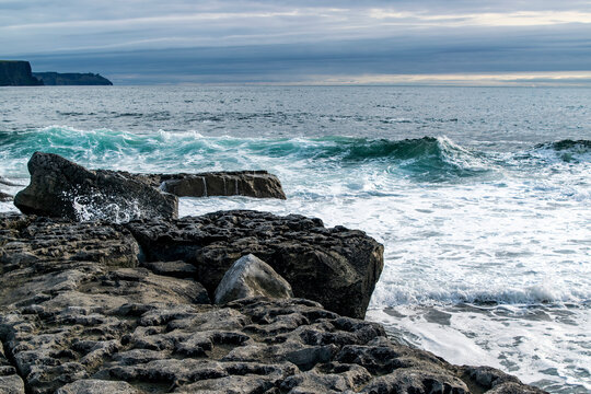 Ireland, Dooling Pier, ocean waves crashing against limestone rocks, known as the Slievenaglasha Formation. 
