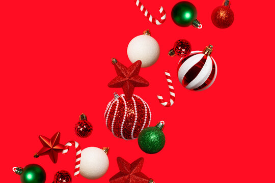 Festive Christmas background with red, green and white ornaments, stars and candy canes arranged diagonally on a red backdrop. Ideal for banners, cards, social media and holiday advertising.
