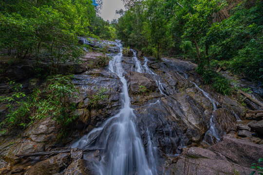 Tropical mountain scenery featuring the iconic Ngao Waterfall, one of Ranong's best-known natural landmarks, attracting visitors with its impressive cascade and lush national park environment.
