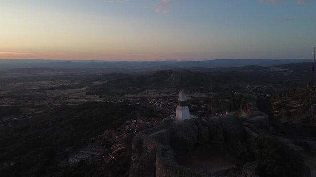 Triangulation pillar overlooking Monsanto, Portugal, with panoramic views across mountains and valleys. Historic high point surrounded by granite rocks and dramatic landscapes.