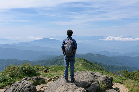 山頂から雄大な絶景を望む登山者の後ろ姿