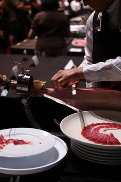jamonero experto cortando jam&oacute;n con cuchillo jamonero