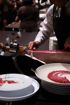 maestro cortador de jam&oacute;n ib&eacute;rico cortando lonchas con un cuchillo