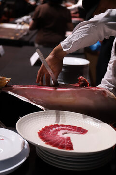 experto jamonero cortando jam&oacute;n ib&eacute;rico con cuchillo jamonero