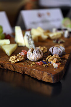 bodeg&oacute;n de quesos con frutos secos y higos en una mesa de madera estilo rustica