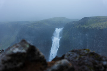 Fototapeta premium Majestic Waterfall Cascading Through Misty Icelandic Canyon Valley