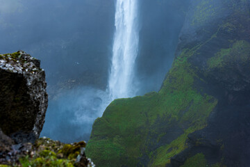 Majestic Waterfall Cascading Down Moss-Covered Canyon in Iceland © Earthly Shots