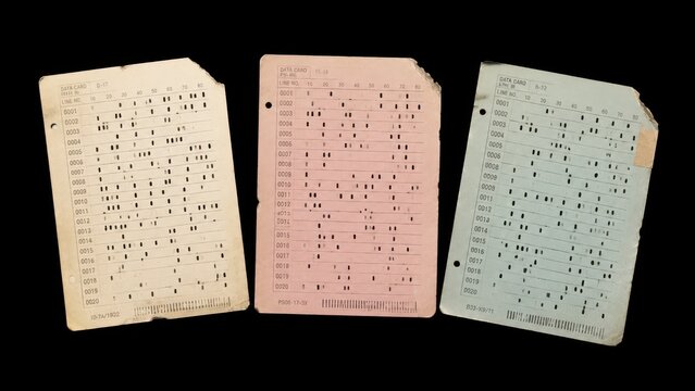 Three vintage punched data cards isolated on black background