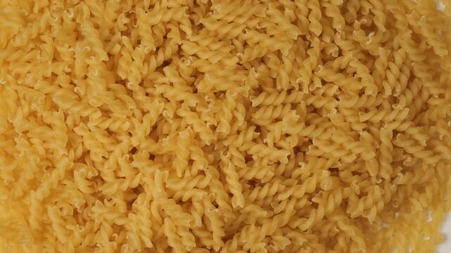 Uncooked fusilli pasta rotating in a loop