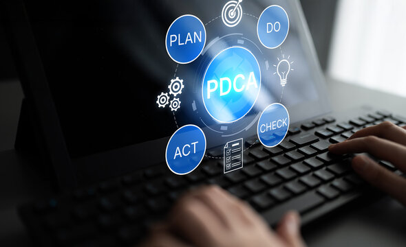 PDCA Cycle Concept Represented on Laptop Screen with Hands Typing and Graphic Elements Illustrating Plan, Do, Check, and Act Approach in Business Management. Bitwise.