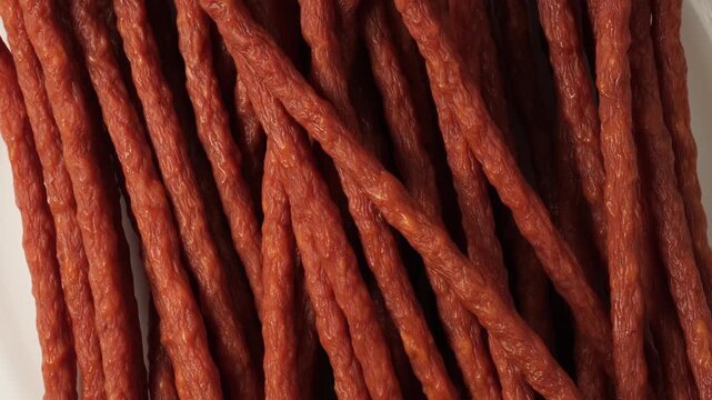 Smoked sausage sticks rotating on white background