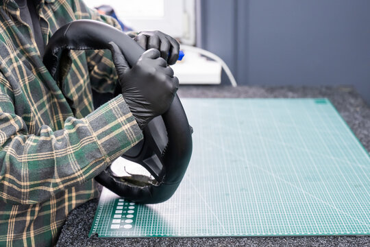 The mechanic changes the cover on the car steering wheel.