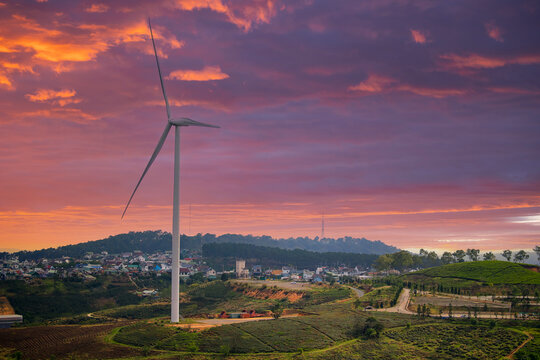 Wind turbine at sunset over rolling hills and quaint village in Da Lat Vietnam