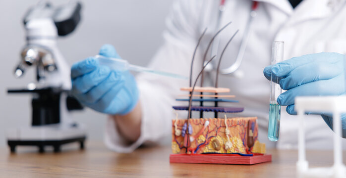 Banner Scientist performing controlled lab procedure on hair follicle model