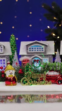 A yellow car drives up to the decorated Christmas town