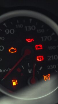 A driver initiates the car startup process by turning the key in the ignition switch, dashboard warning lights briefly flicker as the engine begins to start, preparing the vehicle for operation