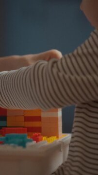 A mother and child engage in a playful learning activity at home with colorful building blocks, promoting family bonding through educational play, in a warm domestic setting