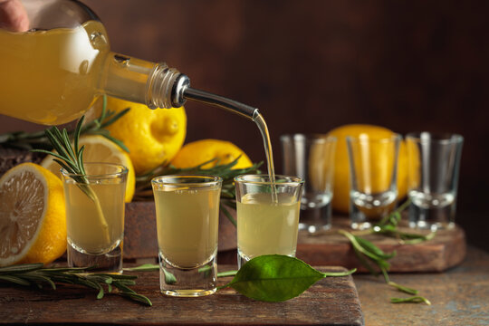 Italian liqueur Limoncello with fresh lemons and rosemary branches.