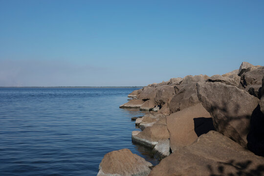 Rocky coastal breakwater beside calm blue sea