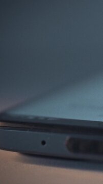 At night in darkness, a smartphone screen lights up as the device activates, displaying an incoming call icon while a ringtone sounds, and a notification appears, and the phone's wake-up process