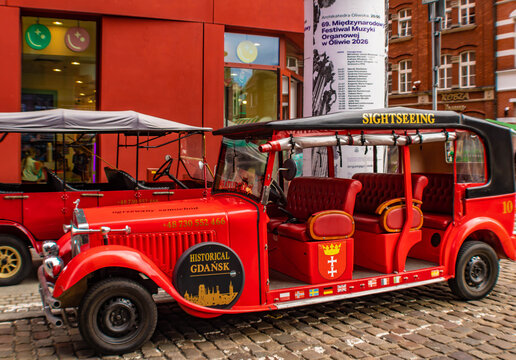 Gdansk, Poland - July 8th 2026: Red sightseeing car offering guided historical rides