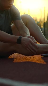 European male athlete warms up on specialized training complex, performing joint mobility drills endurance exercises in professional sports gear, focusing on conditioning and performance preparation