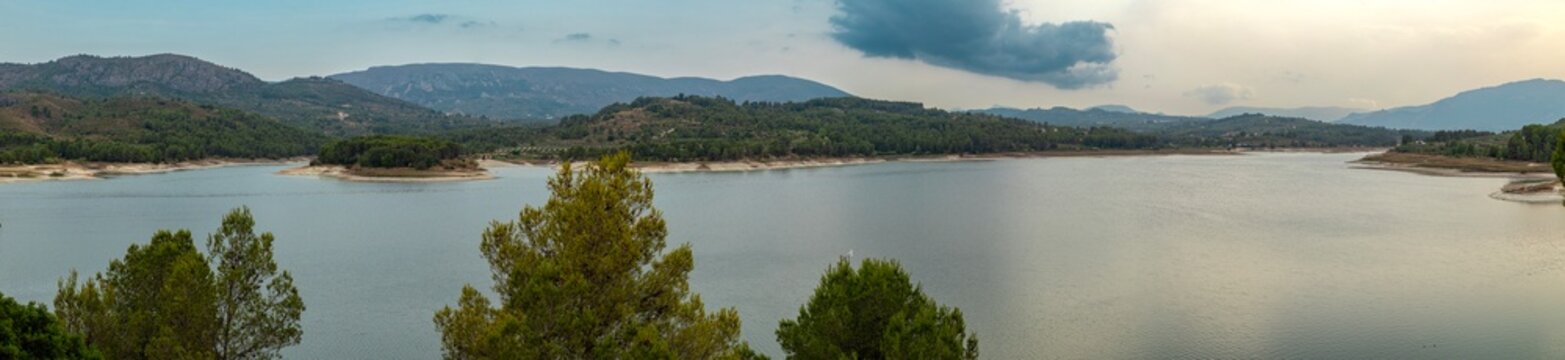 Beniarres reservoir view surrounded by hills and mountains in Alicante Spain at sunset