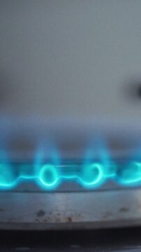 On kitchen counter, gas stove's burner clicks and blue flame erupts, providing immediate heat for cooking, scene captures the routine heat-generation process essential to everyday meal preparation