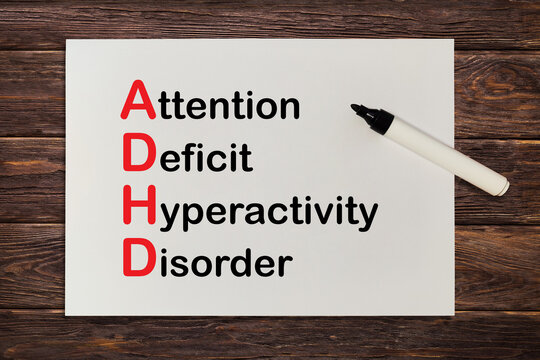 Attention deficit hyperactivity disorder ADHD concept. ADHD Acronym Written on Paper on Wooden Table. 