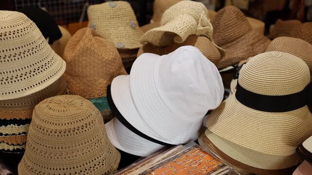 Assorted summer straw hats and panamas displayed on table in a souvenir shop in Nha Trang, Vietnam. Various female beach headwear and sun protection accessories in local store, travel concept.