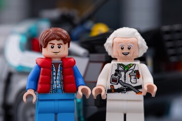 Fototapeta premium Tambov, Russian Federation - July 30, 2026 Portrait of Lego minifigures of Marty McFly and Doc Brown standing in front of the DeLorean time machine car from Back to the Future.