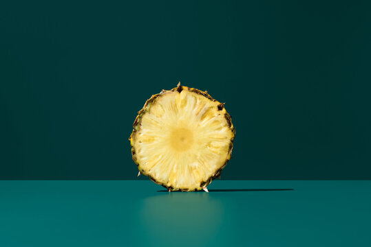 Pineapple slice on teal background
