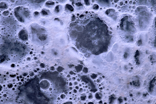 White cream foam bubbles on dark chocolate macro