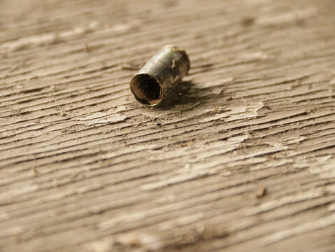 Empty ammo casing on a wooden table 