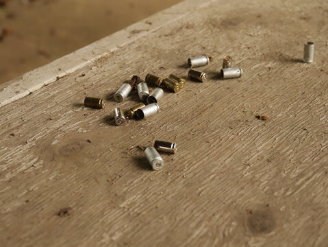 Empty bullet or shotgun shells on a wooden table in a public hunting area
