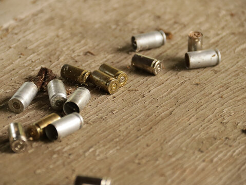Empty bullet or shotgun shells on a wooden table in a public hunting area